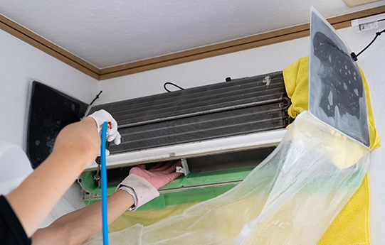 養生したエアコンを洗浄している様子
